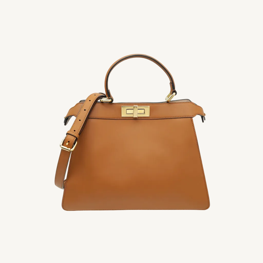 Brown leather handbag with gold hardware on a white background
