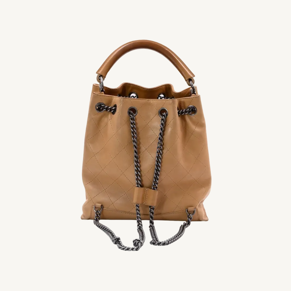 Tan leather handbag with drawstring on a white background